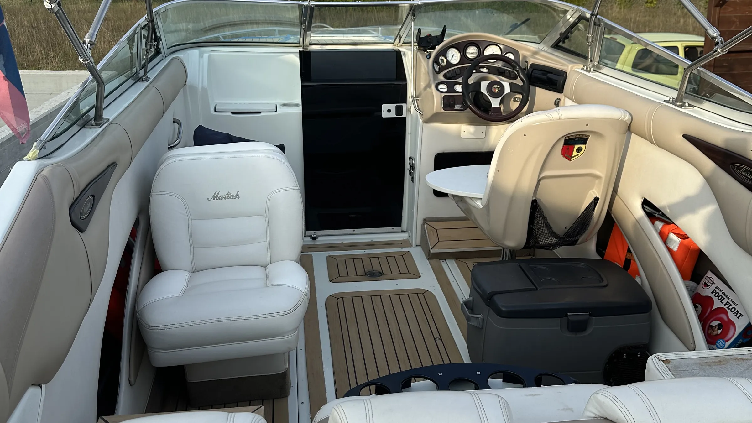 Gereinigtes Cockpit eines Motorboots mit weißen Sitzen und Steuerstand